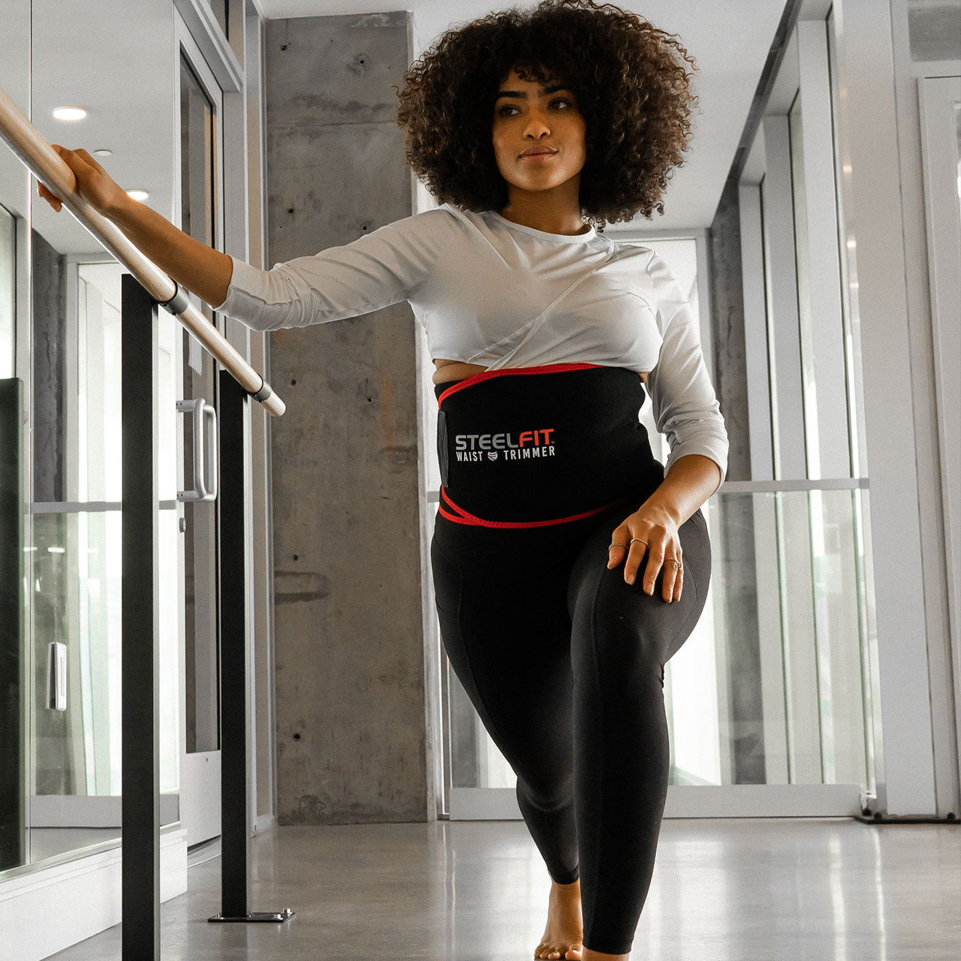 Pretty curly haired woman exercising with a SteelFit adjustable waist trimmer