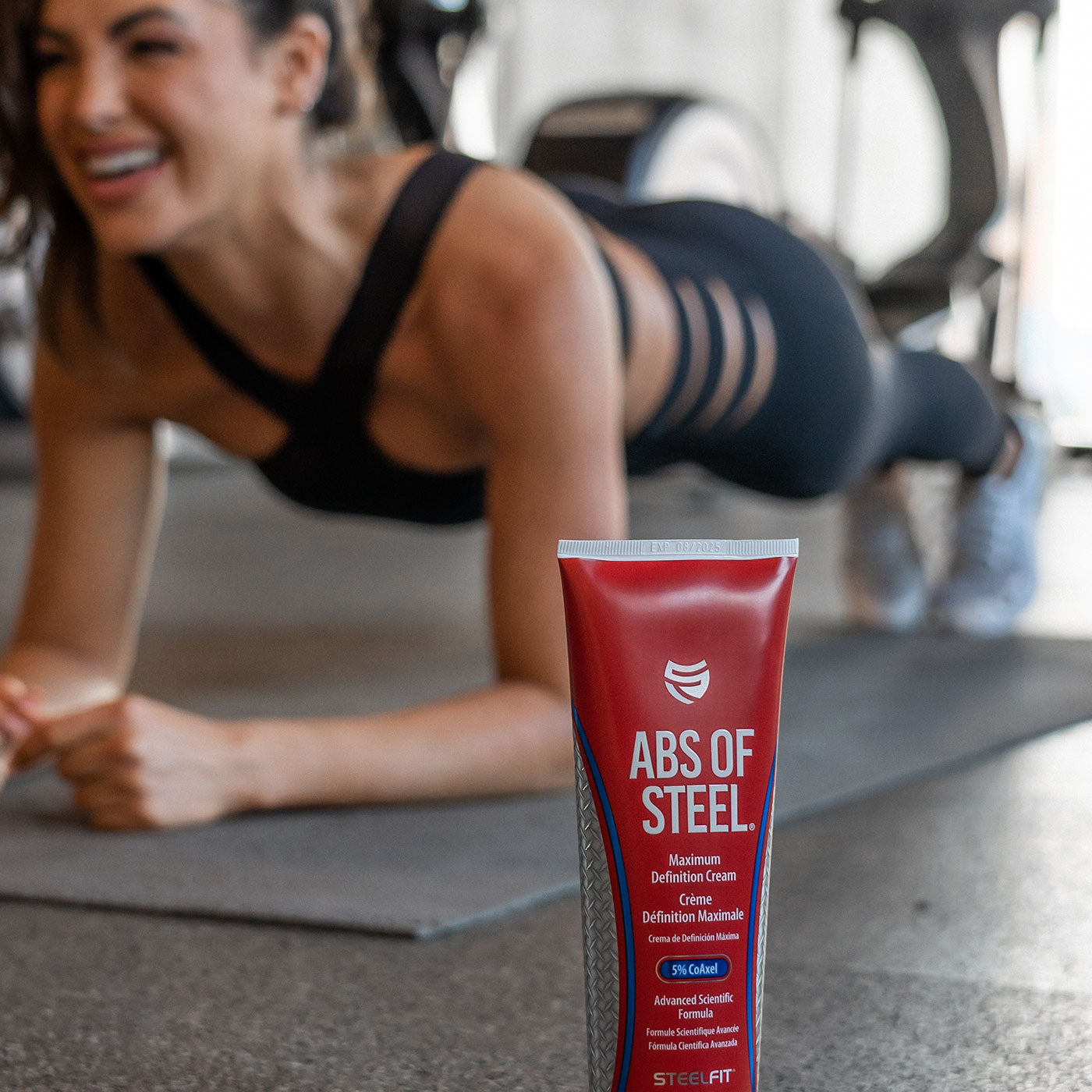 Beautiful woman doing a plank with her Abs of Steel cutting cream