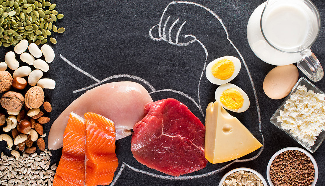 A bowl of buckwheat, cottage cheese, and a glass pitcher of milk next to an egg on a chalkboard, emphasizing healthy food choices.