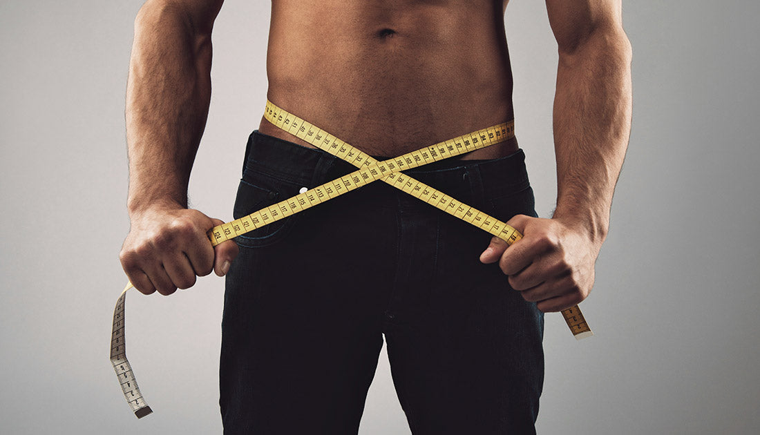 A man measuring his waist with a tape, highlighting fitness and body measurement, related to SteelFit USA's health and fitness focus.