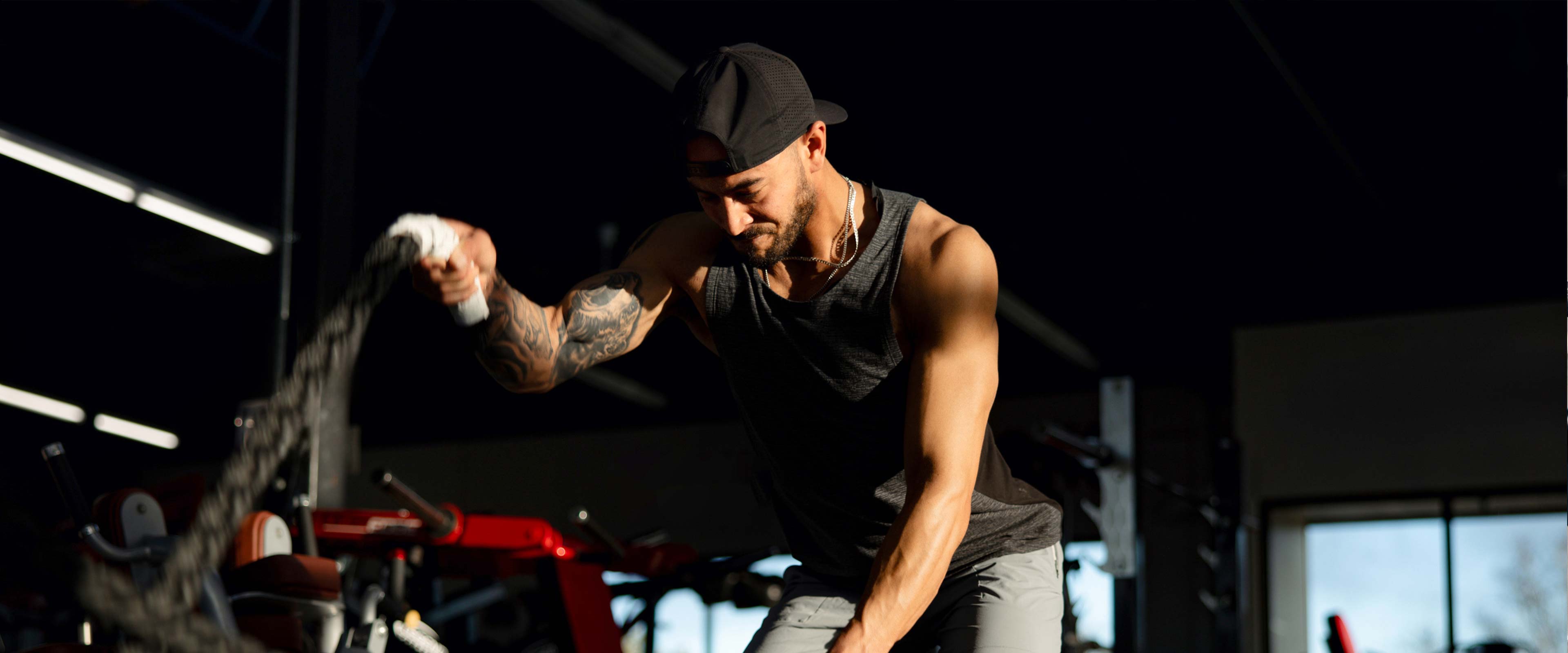 Fit male exercising with battle ropes