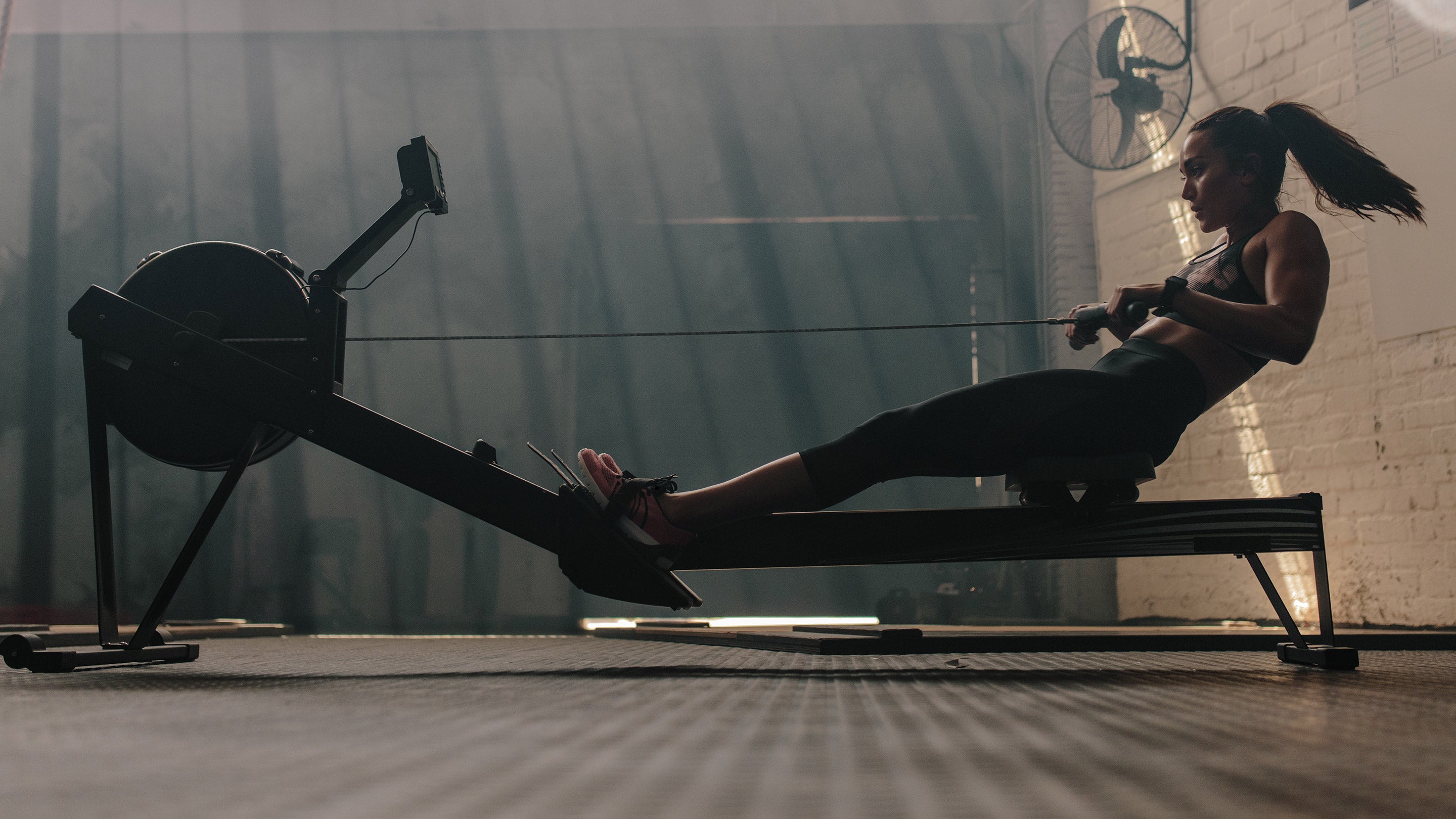 A woman exercising on a gym machine, highlighting fitness and workout routines, with a focus on leg muscles and athletic attire.