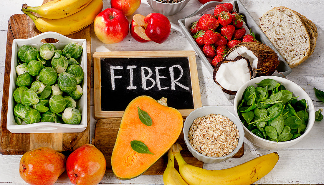 A variety of fresh fruits and vegetables, including a bowl of oatmeal and spinach, on a table, highlighting nutritious, whole foods.