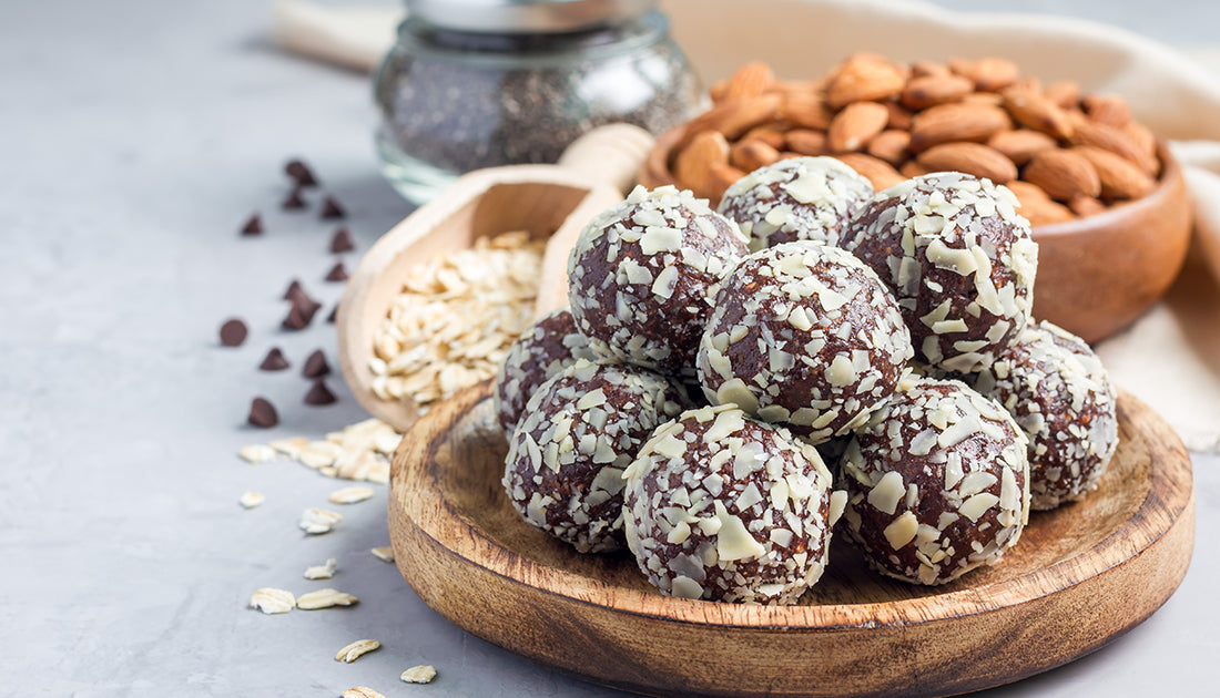 A bowl of chocolate balls topped with nuts, resembling a sweet snack, aligning with fitness-focused nutrition and indulgence.