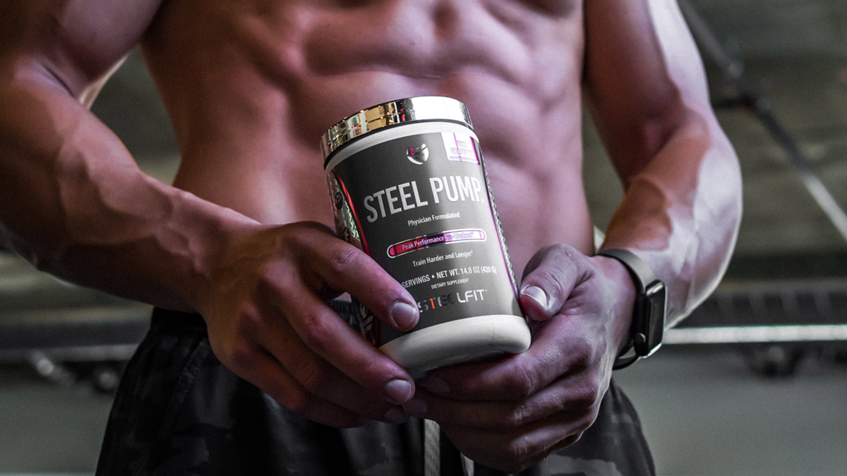 A shirtless man holding a container of protein supplement, showcasing fitness and bodybuilding, aligned with SteelFit USA's health and fitness product offerings.