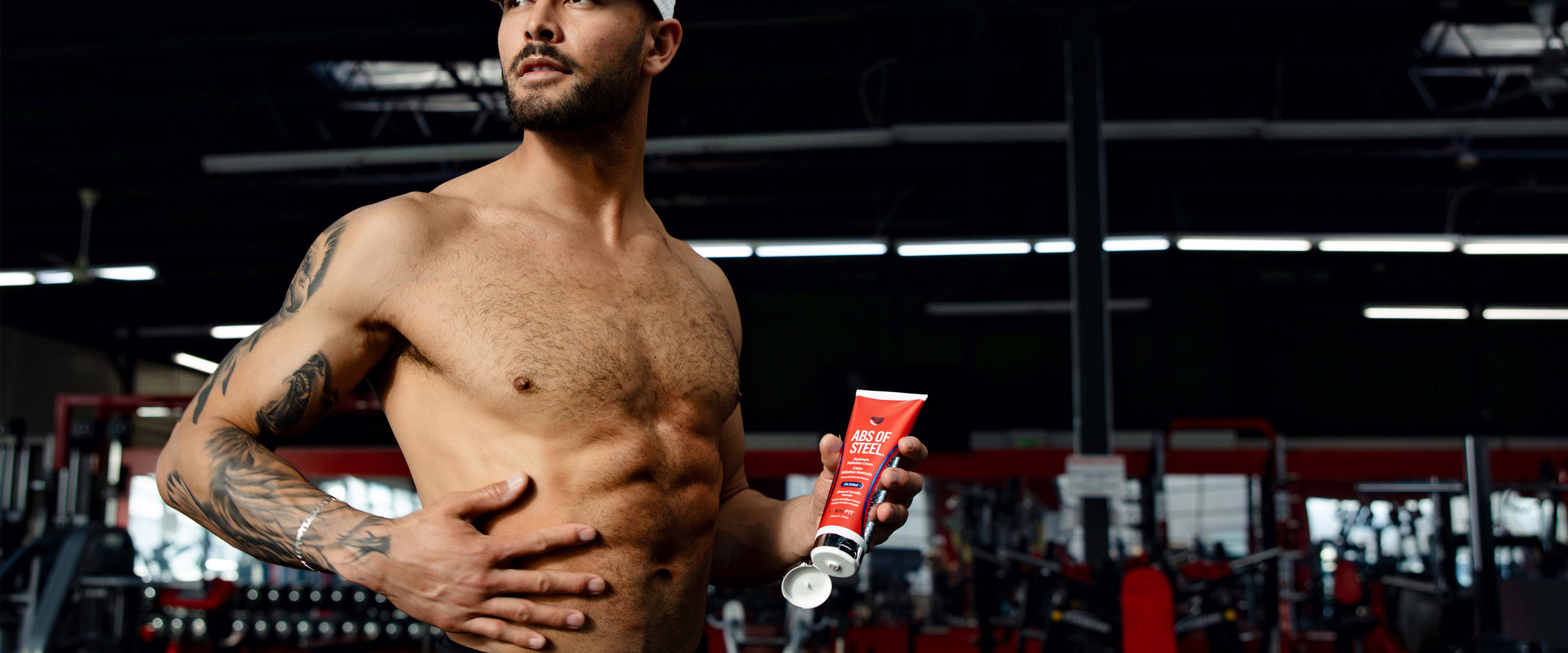 In shape male with shirt off holding Abs of Steel fat burning cream for maximum definition from SteelFit