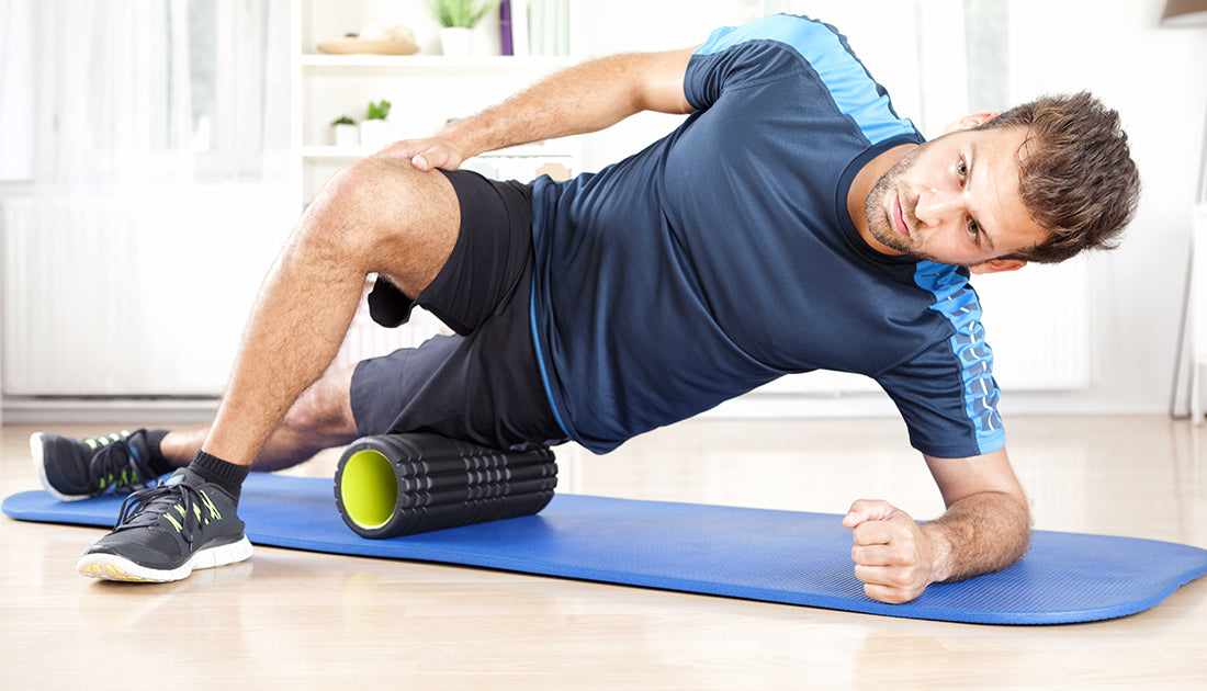 A man using a foam roller on a blue mat, emphasizing fitness and muscle recovery, aligning with SteelFit USA's health and fitness focus.