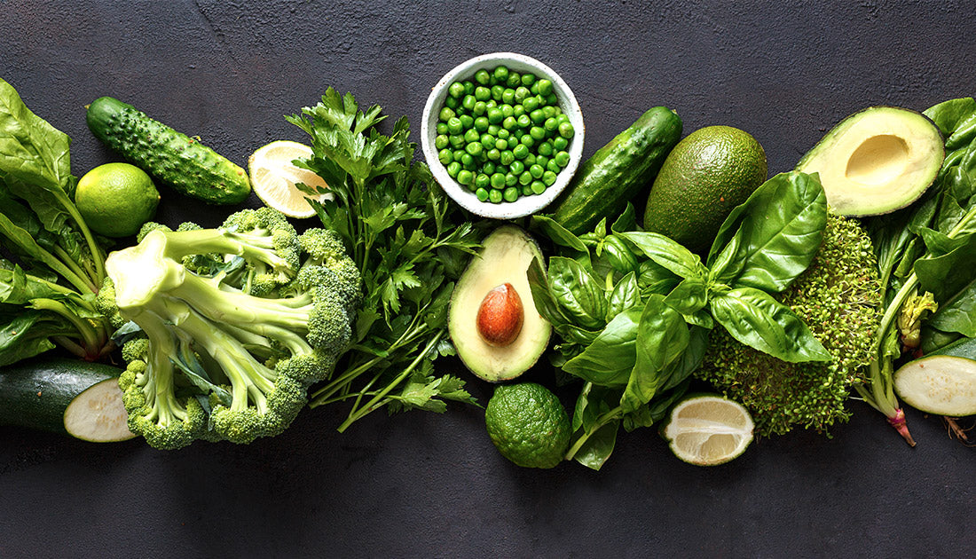 Assorted green vegetables including broccoli, peas, cucumber, lime, and lemon, emphasizing natural, nutrient-rich ingredients for a healthy diet.