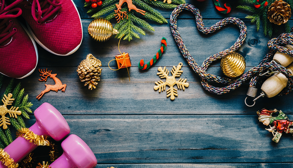 Pink sneakers paired with Christmas decorations and pink dumbbells beside a pine branch; festive and fit-themed imagery for SteelFit USA.