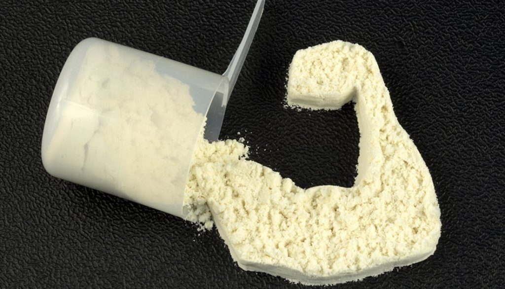 A scoop of protein powder spilling from a container, representing SteelFit USA's sports nutrition supplements for fitness and health goals.