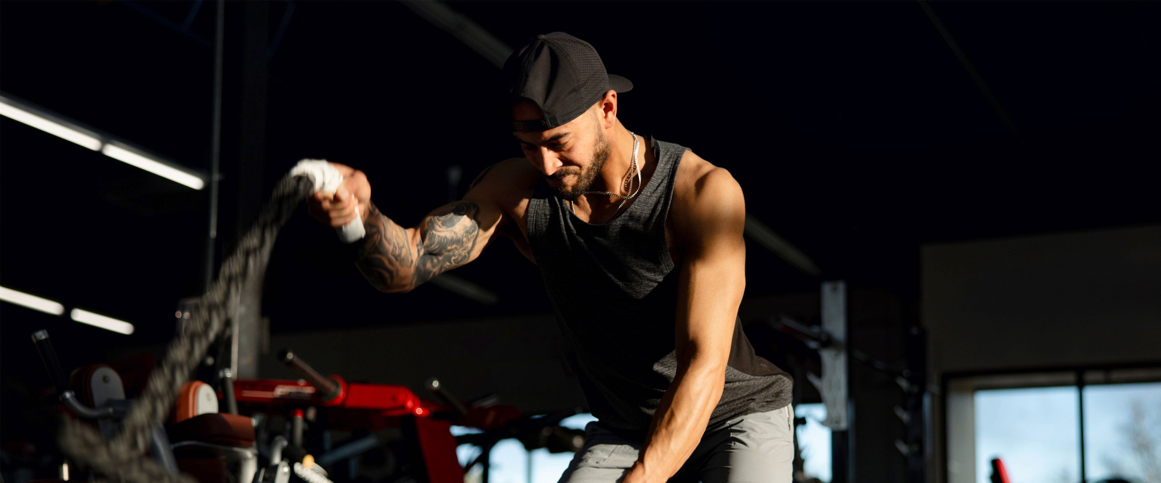 Man doing battle ropes in gym