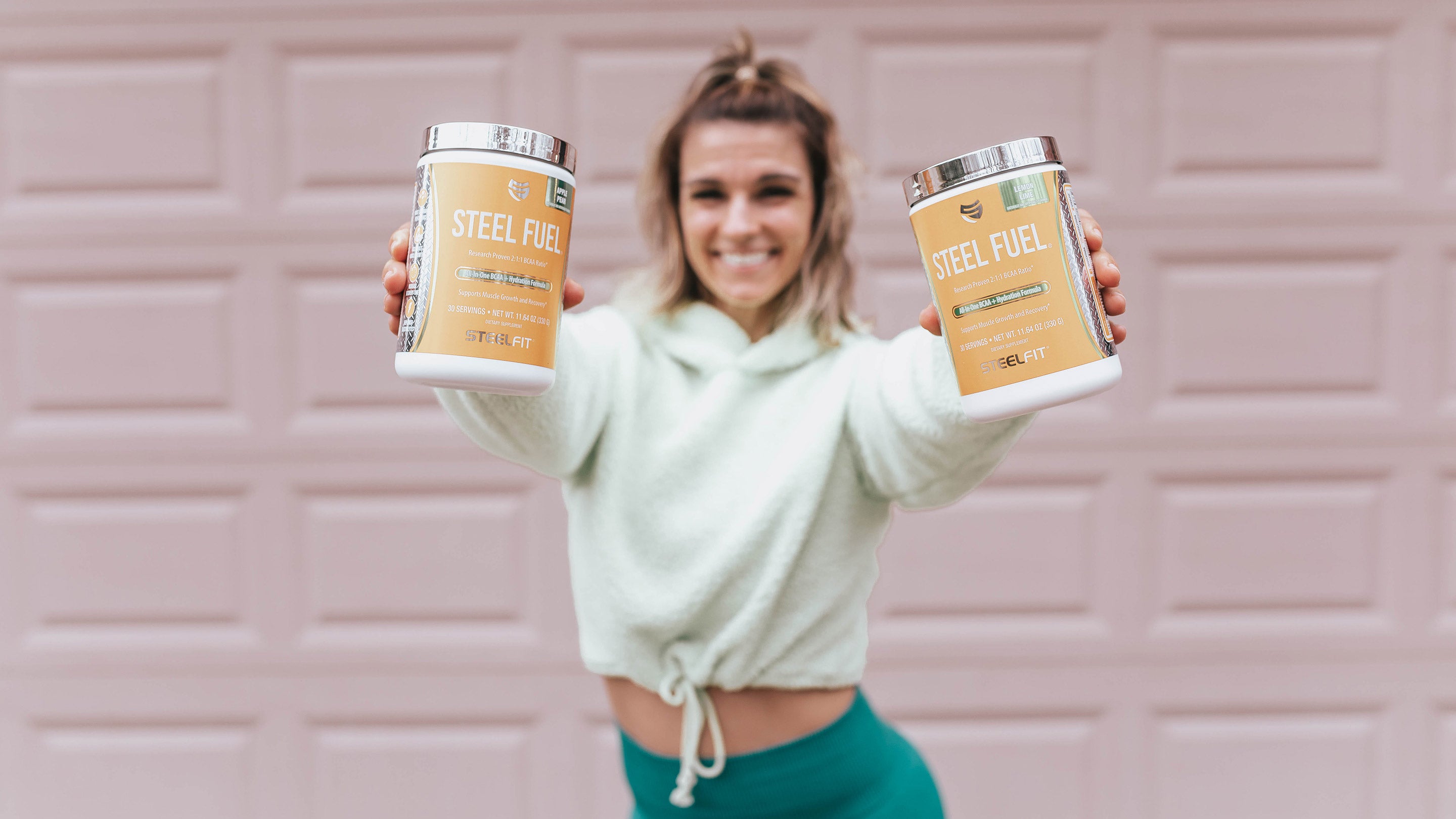 healthy fitness woman holding SteelFit supplements, weight loss, healthy lifestyle, build muscle
