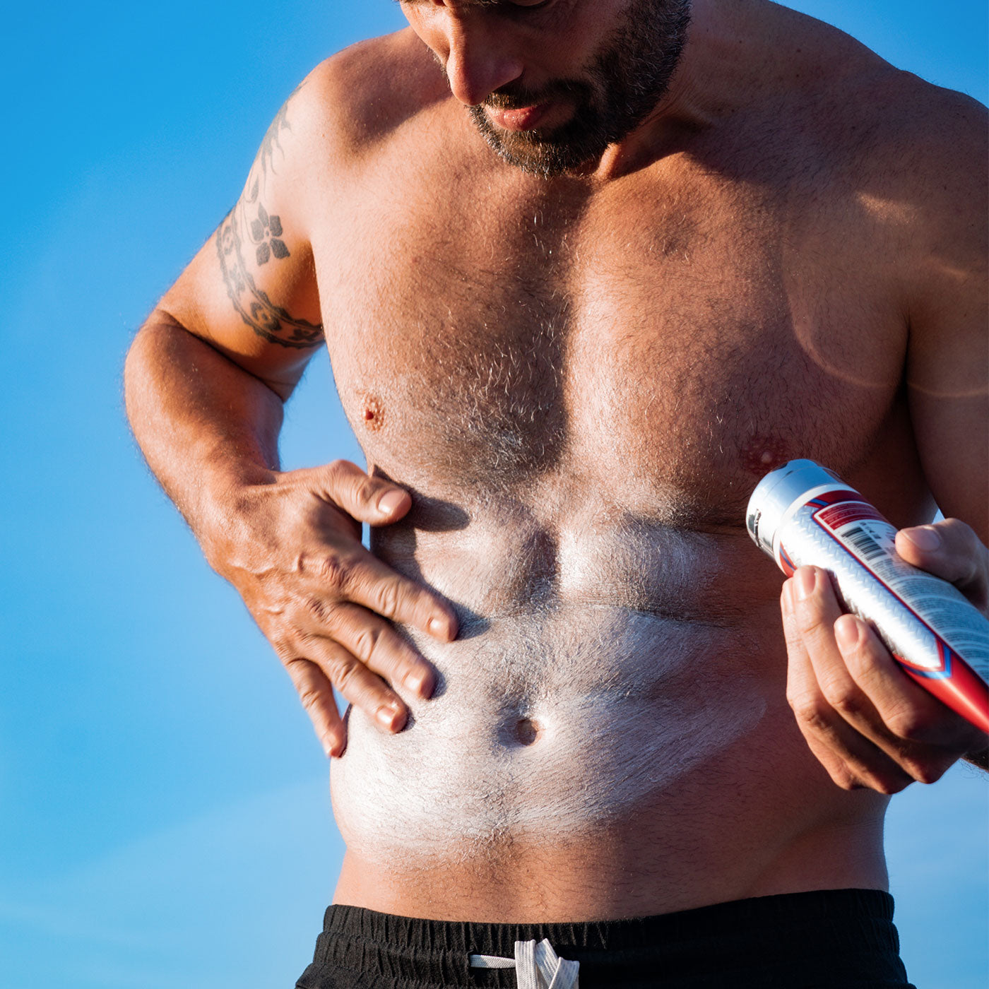 Man applying Abs of Steel Cream in the sun for ripped abs