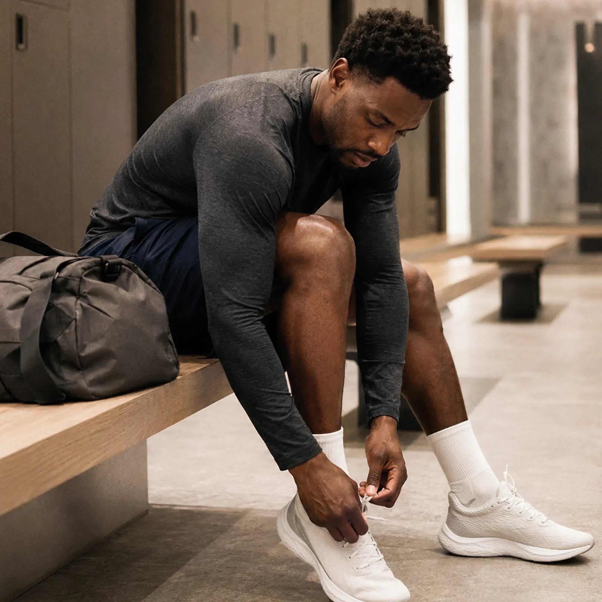 Man tying his shoes in a locker room