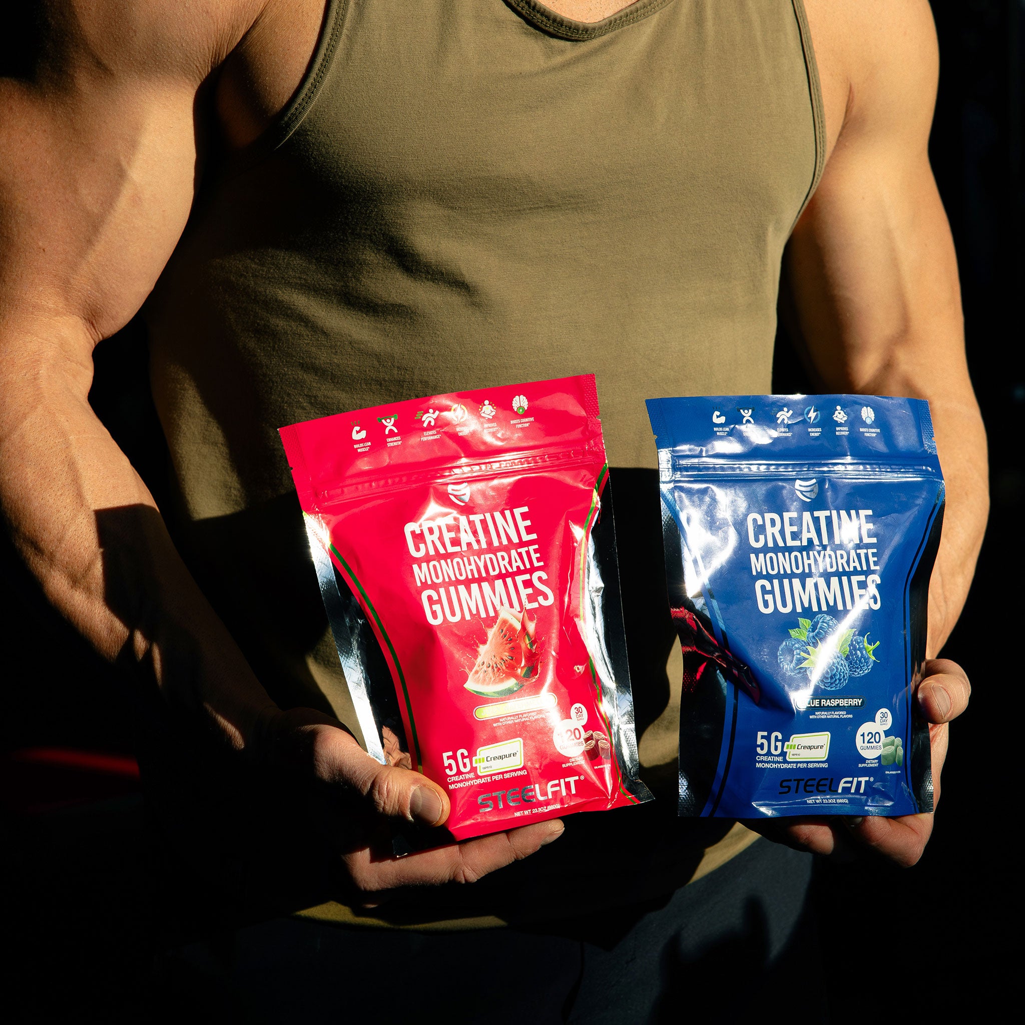 male holding two bags of creapure creatine monohydrate gummies by SteelFit